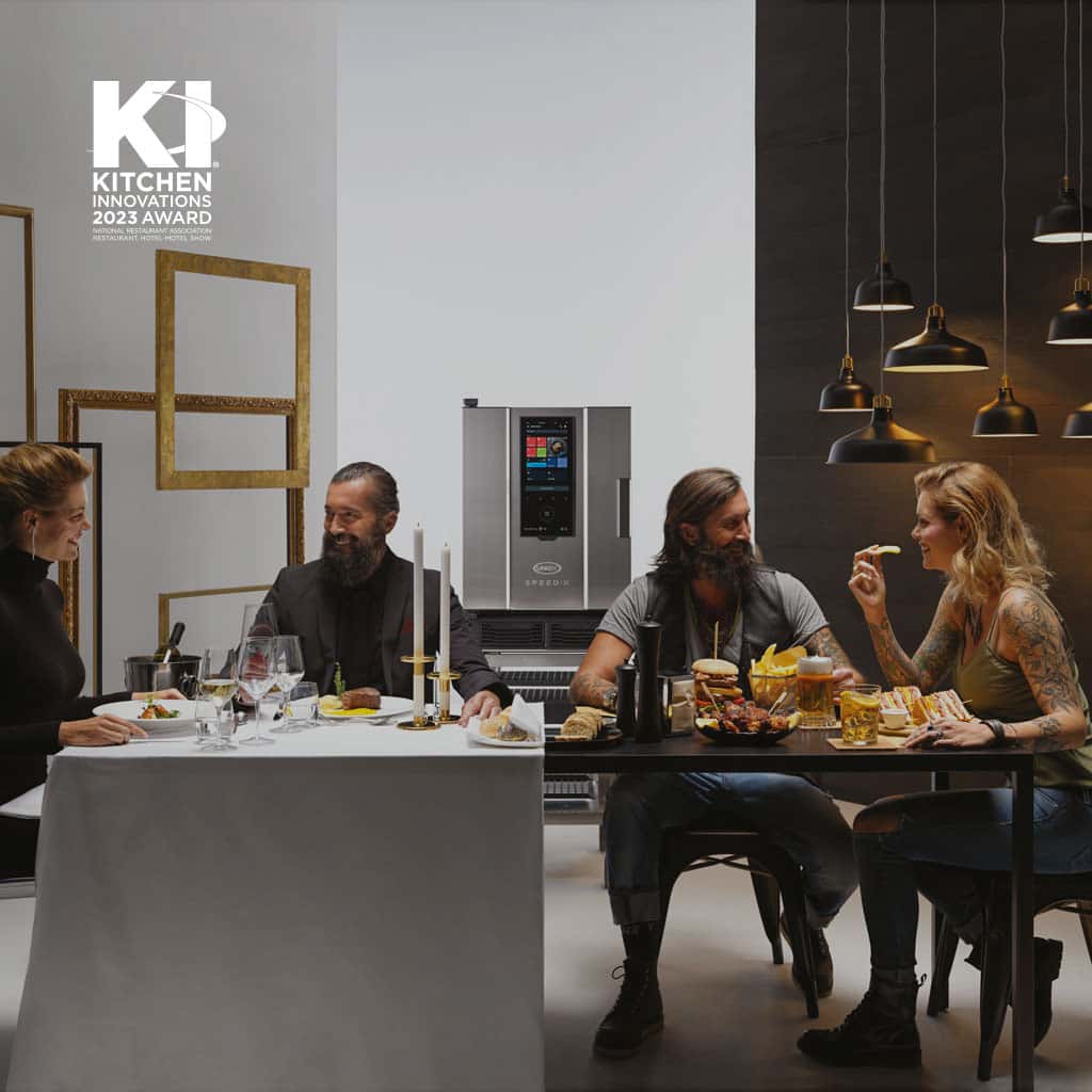 A large dining table, with two couples. One couple are eating fine dining and the other are eating burgers. An Unox speed oven is in the centre.