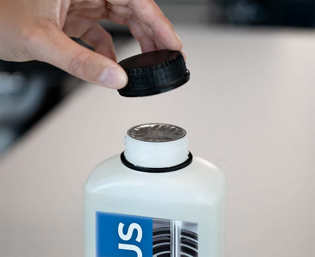 operator opening a bottle of unox commercial oven detergent