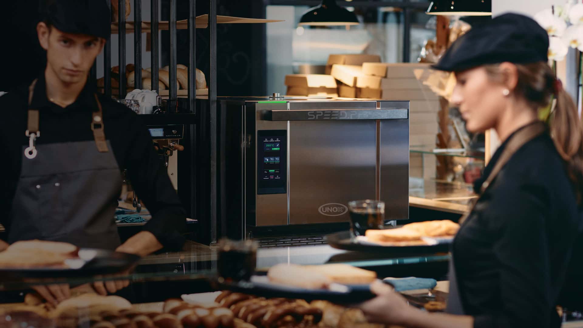 waitress serving sandwiches in front of a professional speed oven