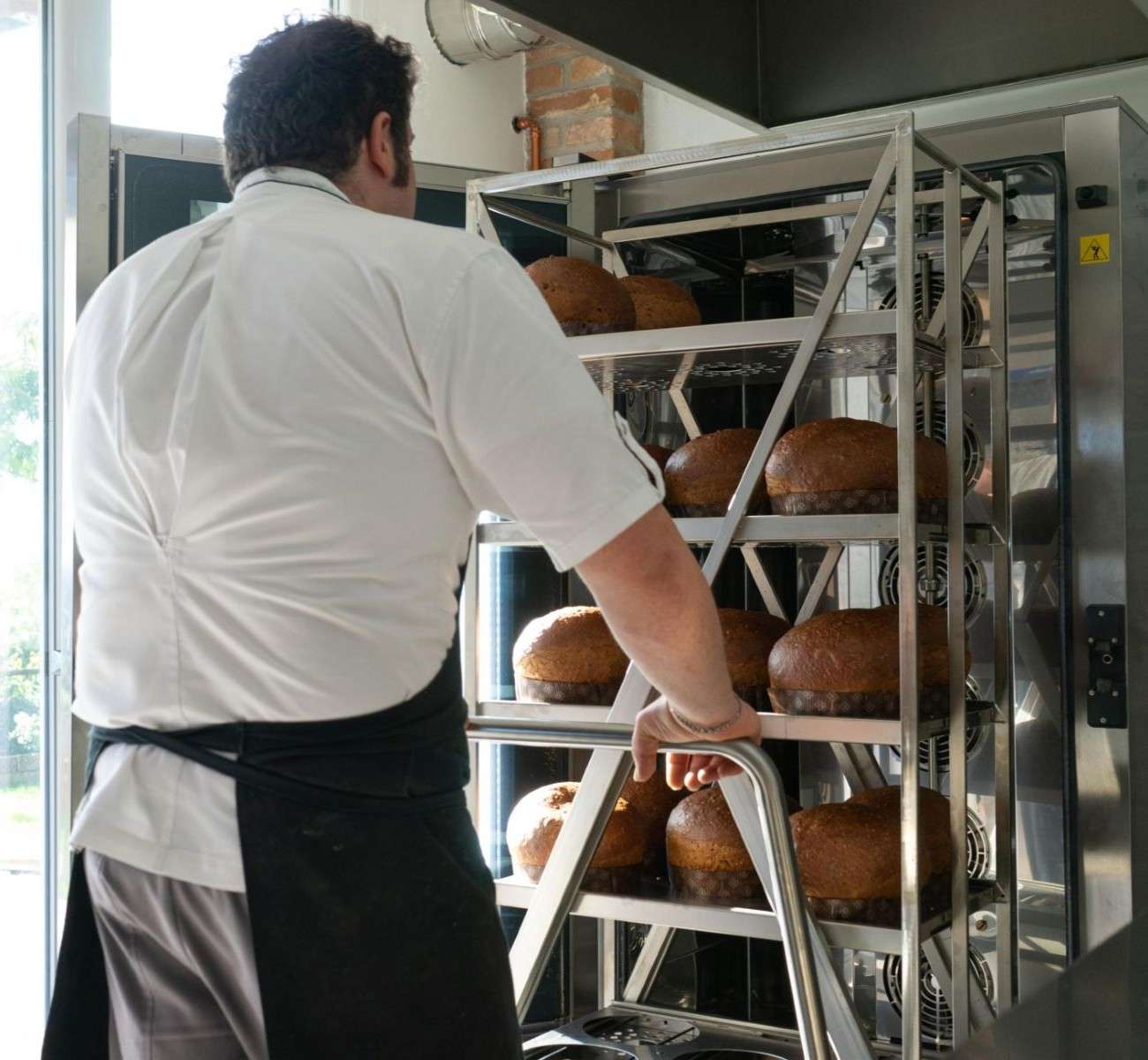 Chef loads a trolley full of panettone into a Unox commercial combi oven.