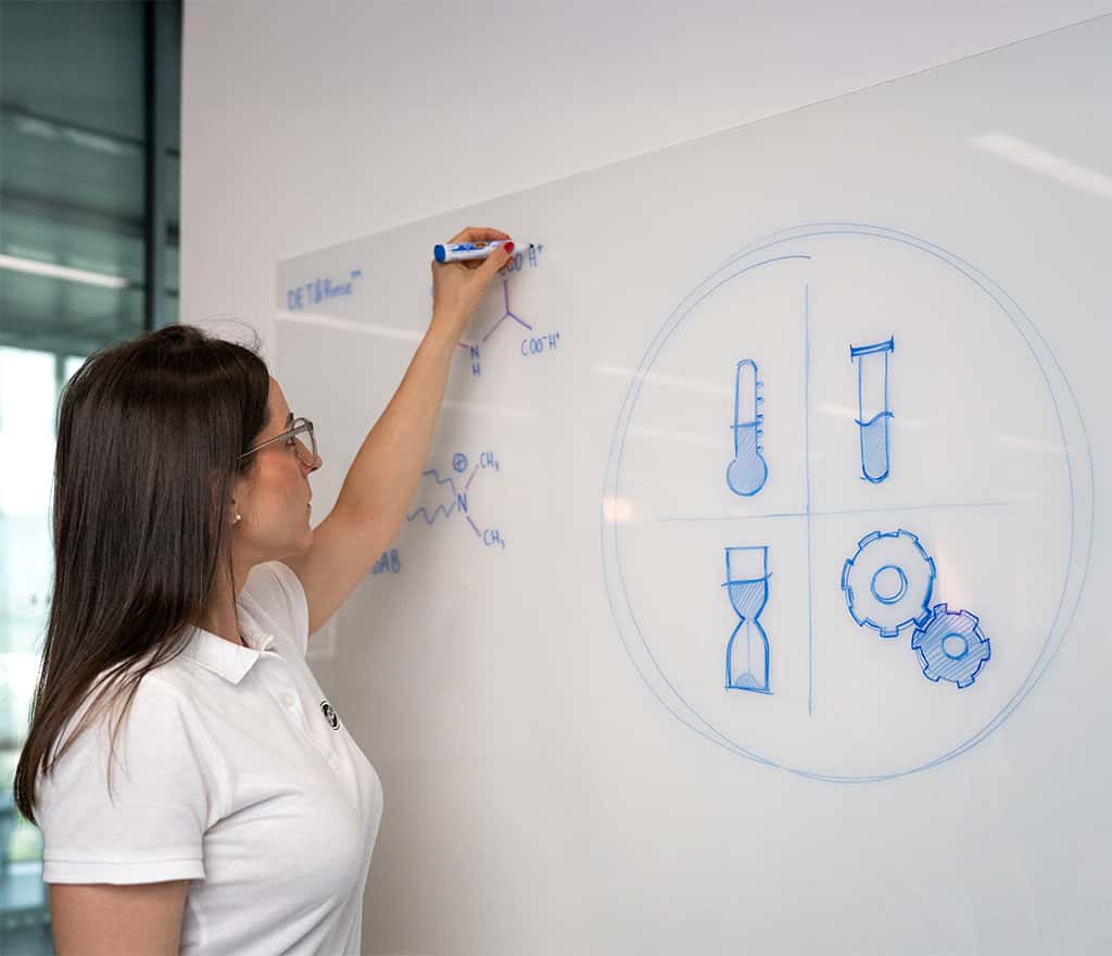 chemist writing a commercial oven cleaning formula on a whiteboard
