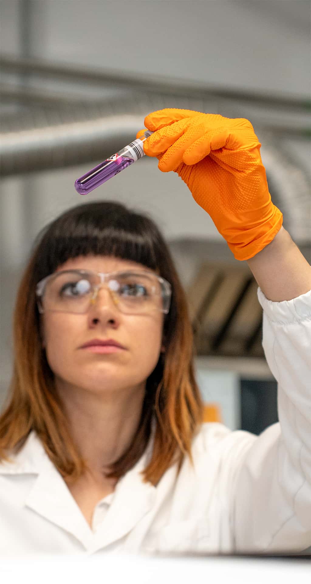 chemist observing a purple test tube in the unox lab