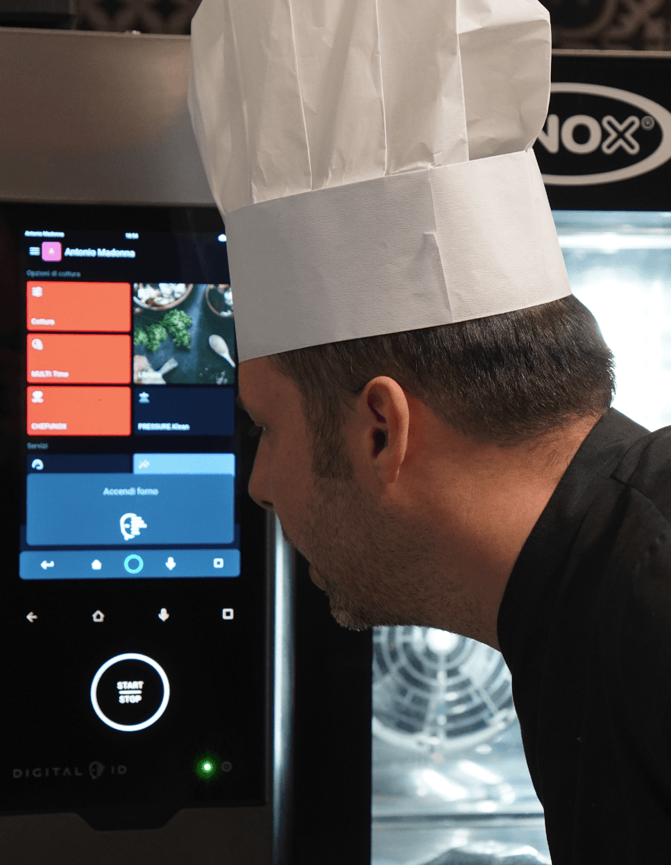 Chef using voice commands through the touchscreen display of a Unox smart commercial oven